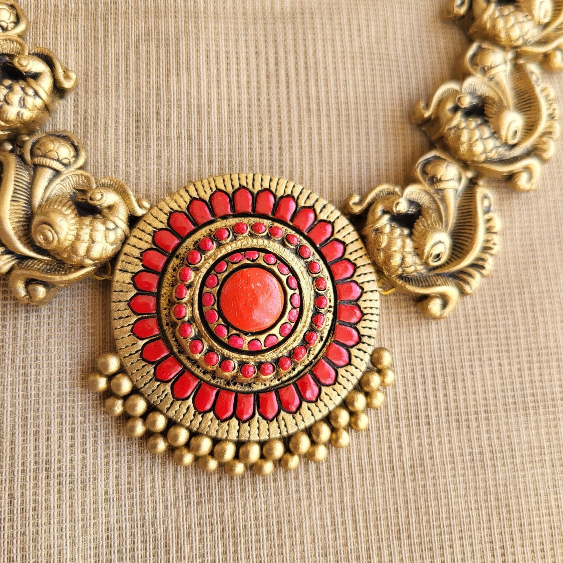 Handcrafted antique gold peacock motif terracotta pendant close-up