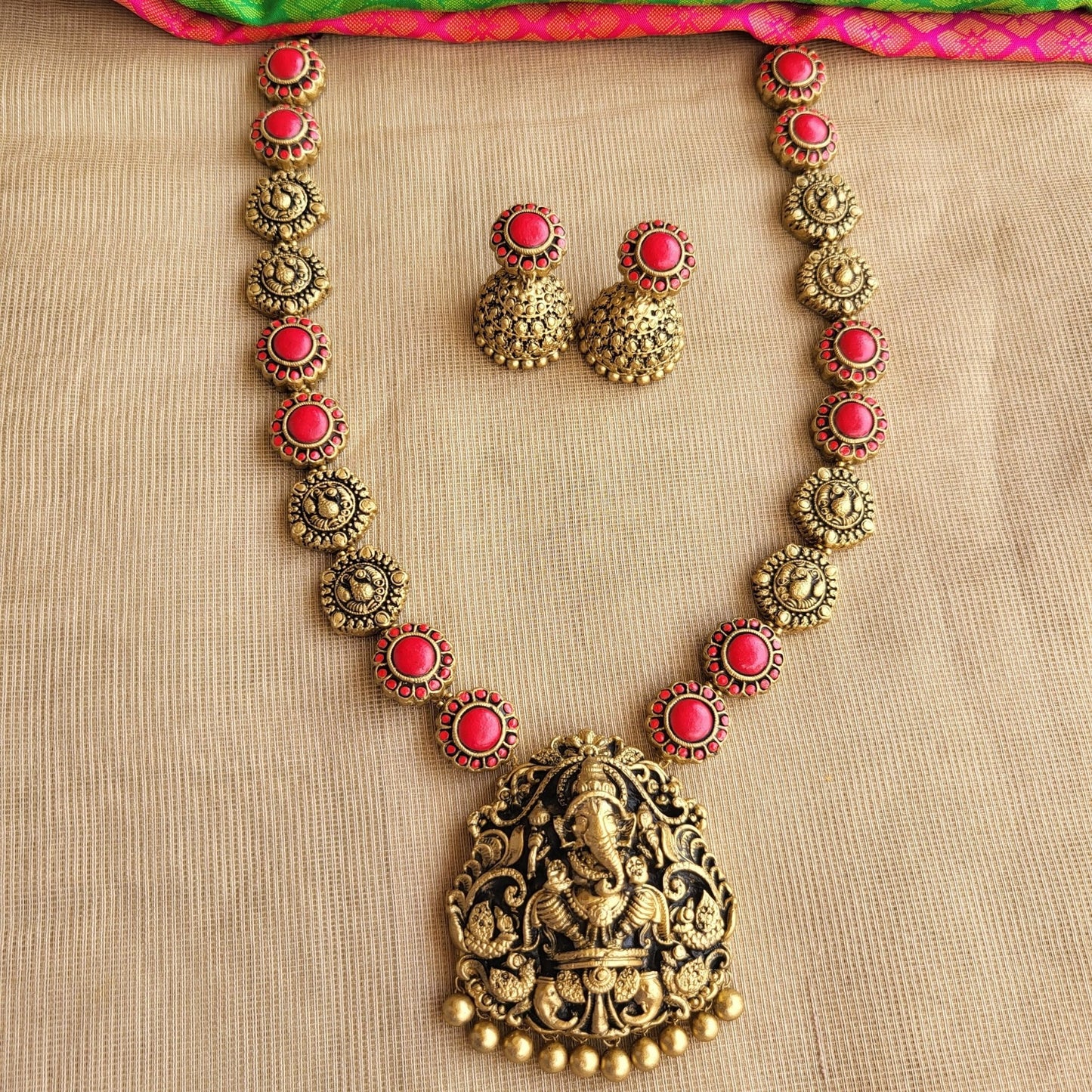 Handcrafted Ganesha pendant with red floral accents