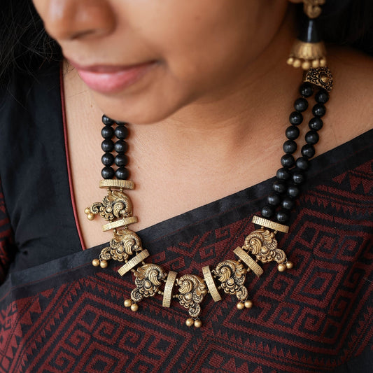 Nerthya - Black and gold dual row necklace with antique gold peacock necklace terracotta jewellery with matching jumkas