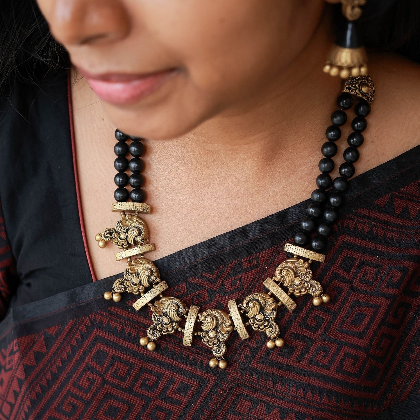 Nerthya terracotta dual-row necklace black antique gold peacock pendant