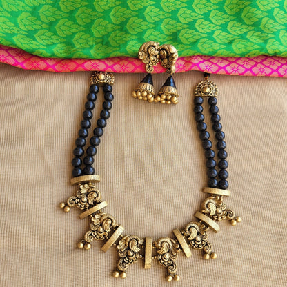 Antique gold peacock motif terracotta pendant close-up