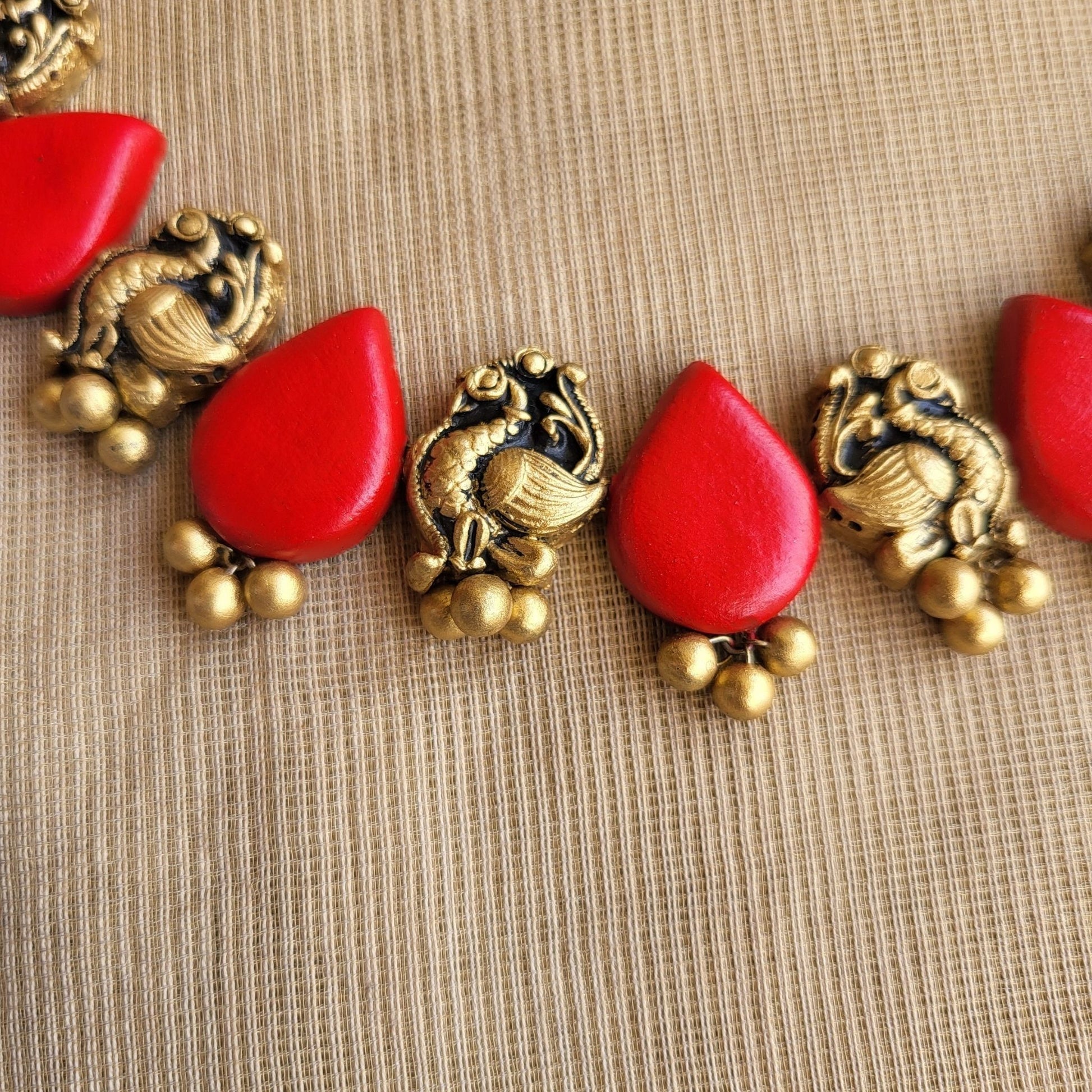 Raindrop shaped terracotta earrings with peacock motif