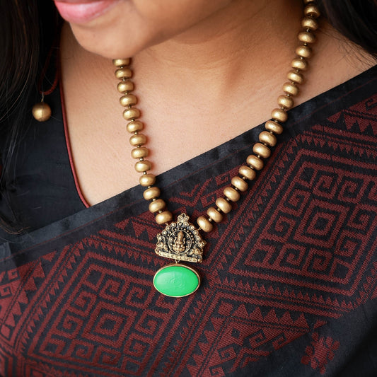 Thulasi - Antique gold disc beads with Lakshmi and green oval element pendant terracotta jewellery with matching earrings