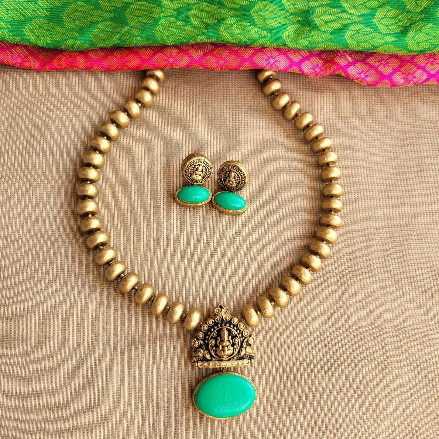 Terracotta Lakshmi pendant with green oval centerpiece