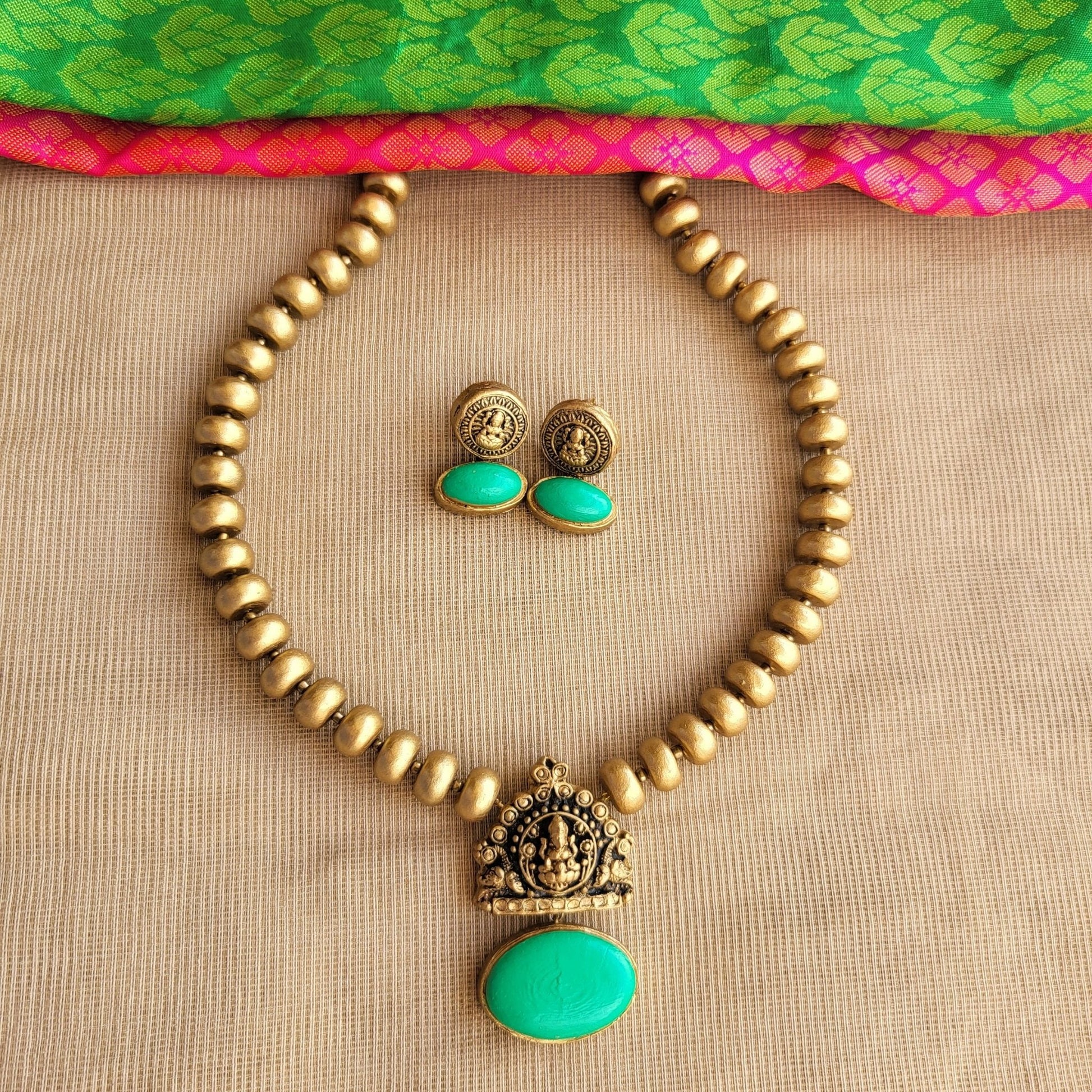 Terracotta Lakshmi pendant with green oval centerpiece